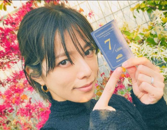 桜井ユキ、女優、カードを手に持ち、こちらを見ている女性